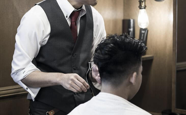 理容師がヘアワックスについてアドバイスしているイメージ